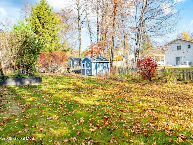 view of yard with a fenced backyard, an outbuilding, and a storage shed