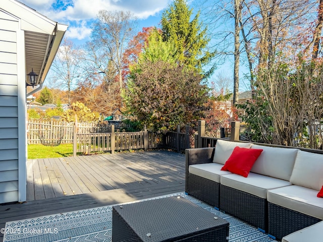 wooden terrace with an outdoor living space and fence