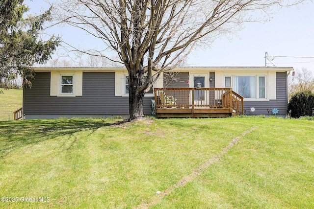 back of house featuring a lawn and a deck
