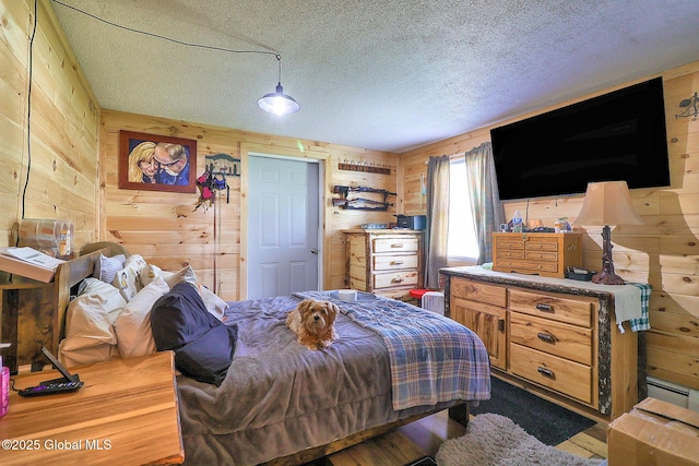 bedroom with wooden walls, a textured ceiling, and dark wood-type flooring