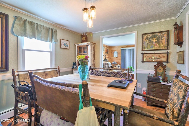 dining area featuring a textured ceiling, ornamental molding, a baseboard heating unit, and wood finished floors