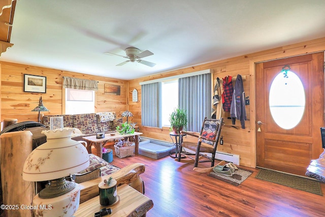 living room featuring plenty of natural light, a ceiling fan, wood finished floors, and wooden walls