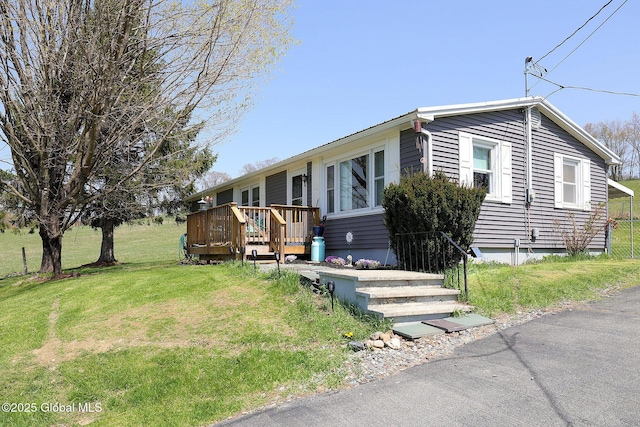 manufactured / mobile home with a wooden deck and a front yard