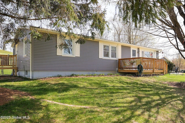 rear view of property featuring a lawn and a deck