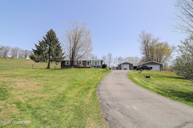 ranch-style home with a garage, an outbuilding, and a front lawn