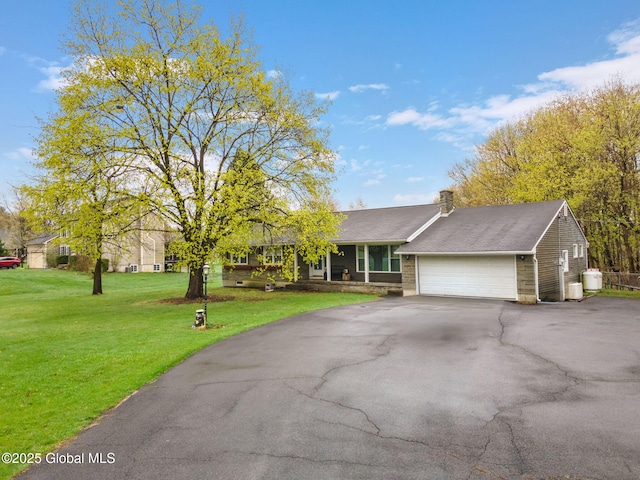 ranch-style home featuring a chimney, a garage, aphalt driveway, and a front yard