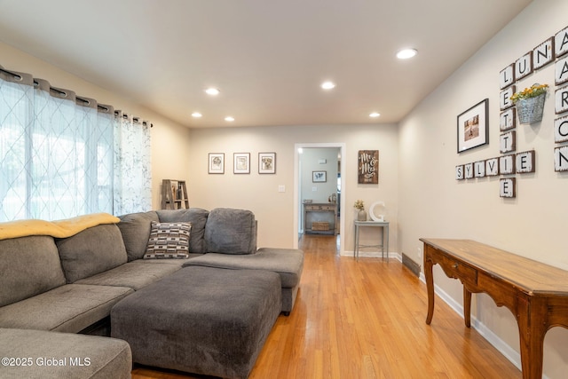living room featuring baseboards, light wood-type flooring, and recessed lighting