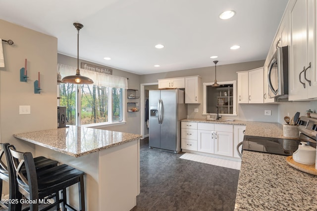 kitchen with recessed lighting, a sink, appliances with stainless steel finishes, and white cabinets