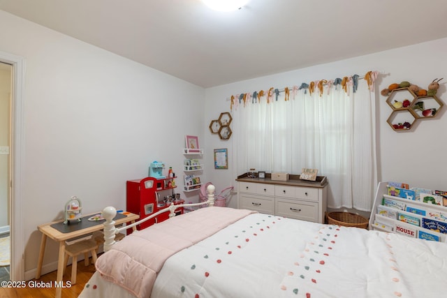 bedroom featuring baseboards and wood finished floors
