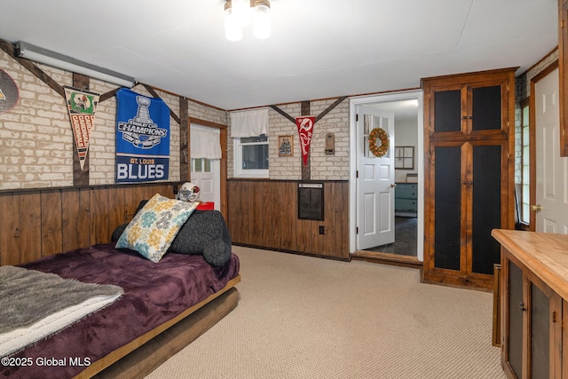 carpeted bedroom featuring wood walls