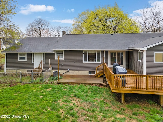 back of house featuring a lawn, a chimney, fence private yard, and a deck