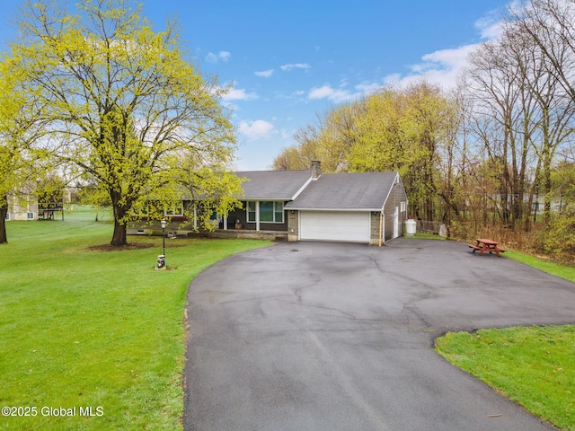ranch-style house with an attached garage, a chimney, driveway, and a front yard