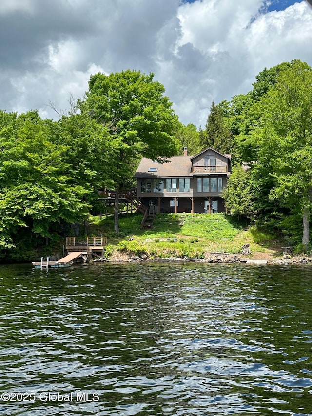 view of water feature with a boat dock and a forest view