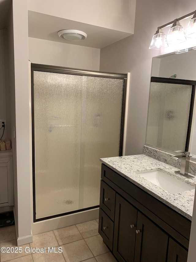 bathroom featuring a shower stall, tile patterned flooring, and vanity