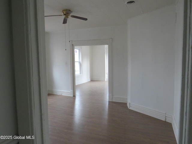 corridor featuring wood finished floors and baseboards