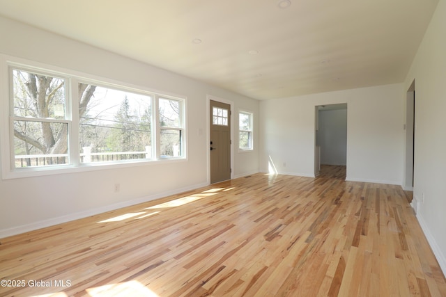 unfurnished living room with light wood-style floors and baseboards