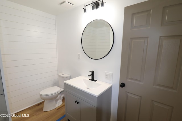 bathroom with vanity, wood finished floors, visible vents, and toilet
