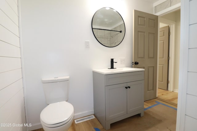 bathroom featuring toilet, baseboards, visible vents, and vanity