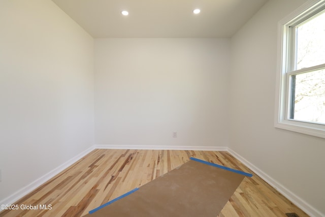 unfurnished room with plenty of natural light, baseboards, and wood finished floors