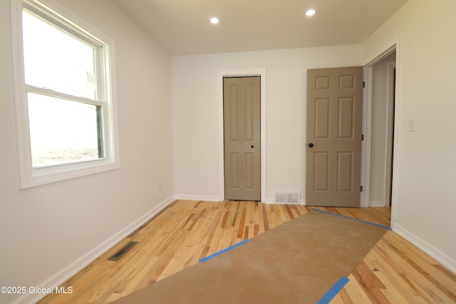 unfurnished bedroom featuring recessed lighting, baseboards, visible vents, and wood finished floors