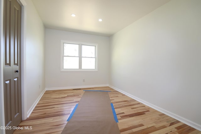 empty room featuring baseboards, recessed lighting, and light wood-style flooring