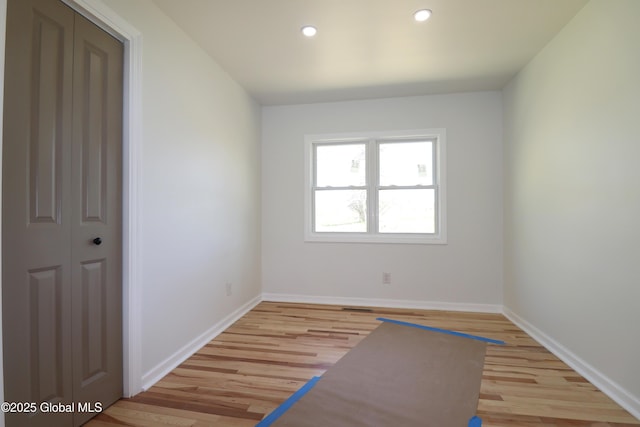 unfurnished room with light wood-type flooring, recessed lighting, and baseboards