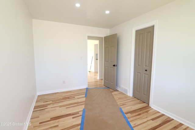 unfurnished bedroom featuring visible vents, a closet, baseboards, light wood-type flooring, and recessed lighting