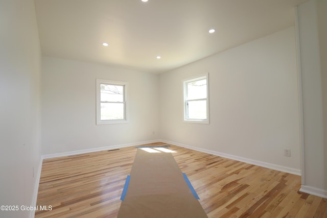 empty room with recessed lighting, a wealth of natural light, and light wood finished floors
