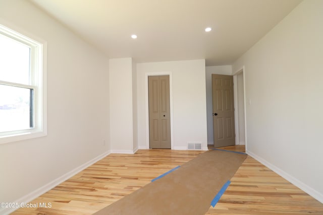 interior space featuring recessed lighting, baseboards, light wood-type flooring, and visible vents