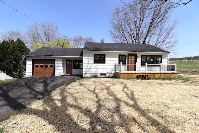 ranch-style house featuring an attached garage, a shingled roof, driveway, and a porch