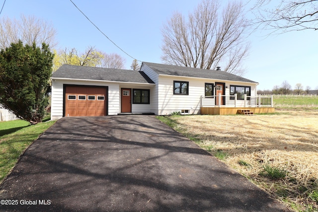view of front of property with an attached garage, aphalt driveway, and a deck