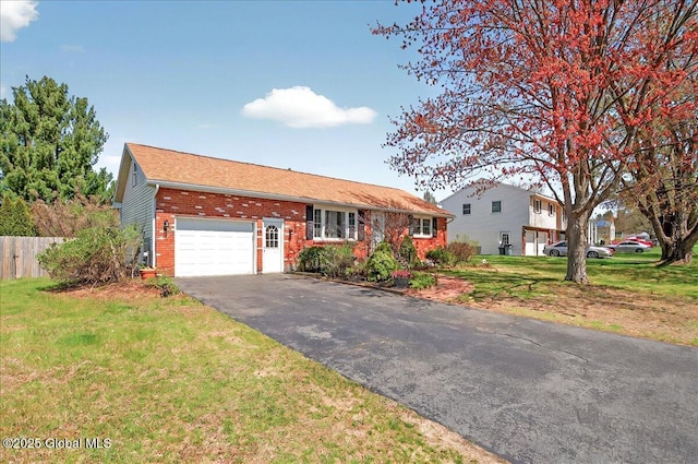 single story home with fence, an attached garage, a front lawn, brick siding, and driveway