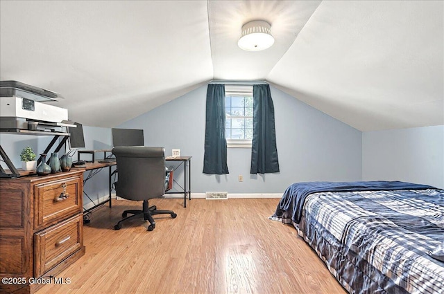 bedroom with baseboards, visible vents, lofted ceiling, and light wood-style floors