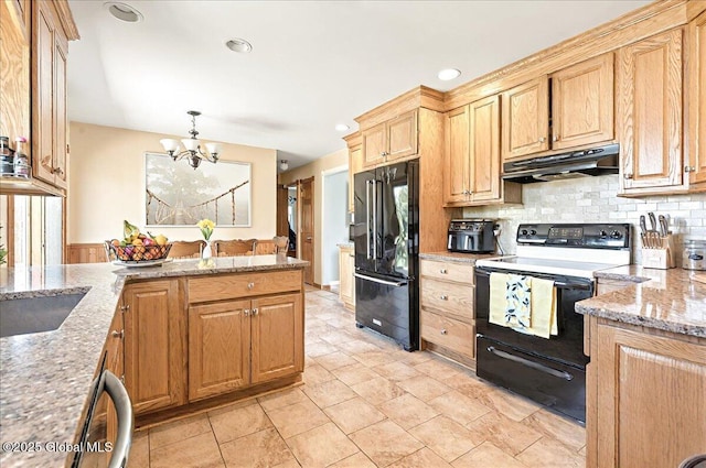 kitchen with tasteful backsplash, light stone countertops, black appliances, a chandelier, and under cabinet range hood