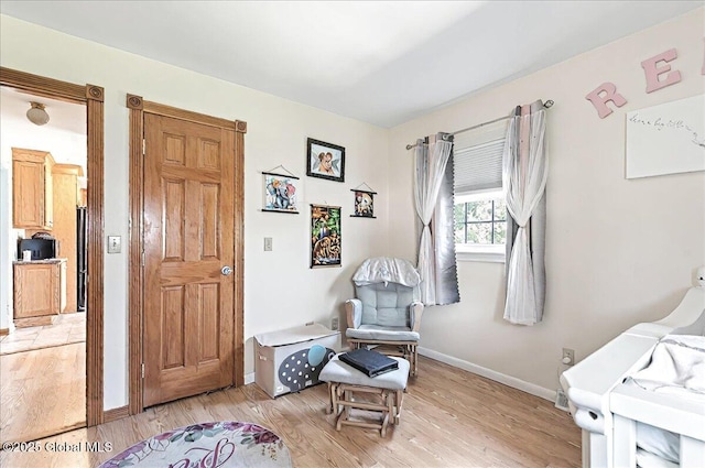 sitting room with baseboards and light wood finished floors
