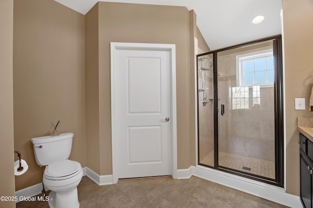 bathroom featuring toilet, baseboards, a shower stall, and vanity