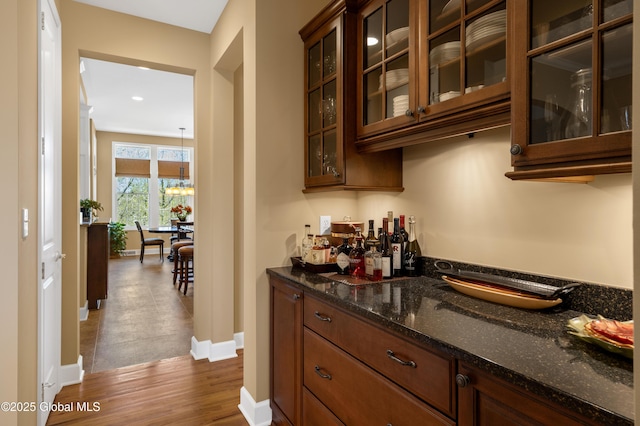bar with an inviting chandelier, baseboards, recessed lighting, a bar, and dark wood finished floors