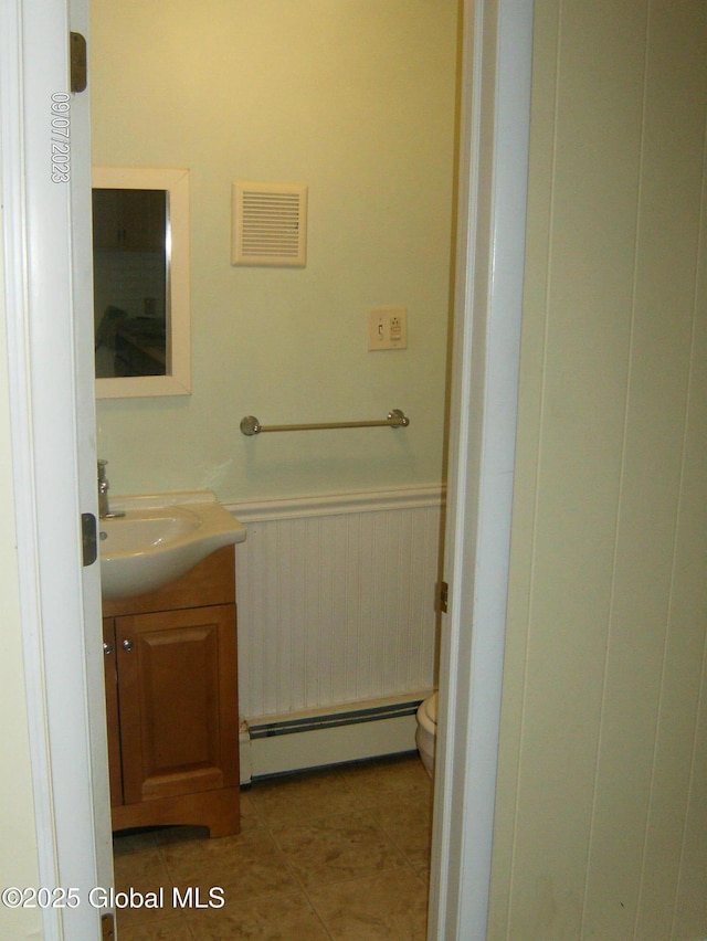 21 Depot St, Greenwich, NY 12834 - bathroom featuring a baseboard radiator, vanity, wainscoting, and tile patterned floors