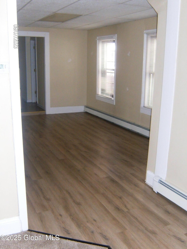 21 Depot St, Greenwich, NY 12834 - spare room featuring a baseboard heating unit, wood finished floors, baseboards, and a paneled ceiling