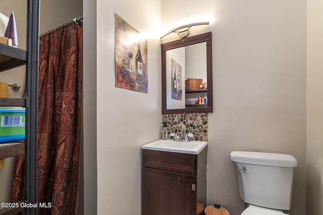 bathroom featuring vanity, decorative backsplash, and toilet