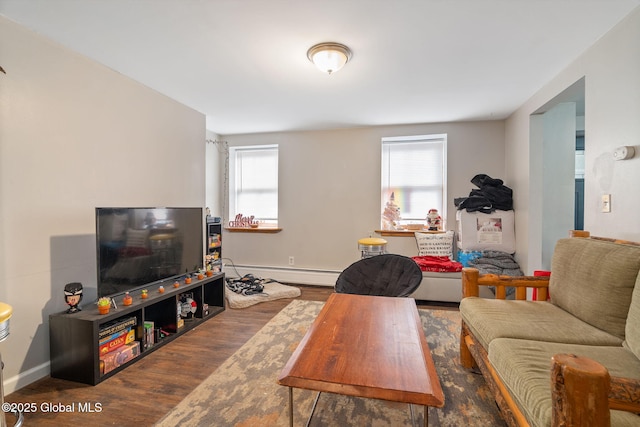 living area featuring baseboards, a baseboard heating unit, and wood finished floors