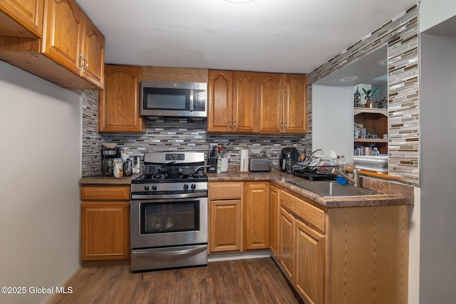 kitchen with a sink, dark wood-style flooring, decorative backsplash, and stainless steel appliances