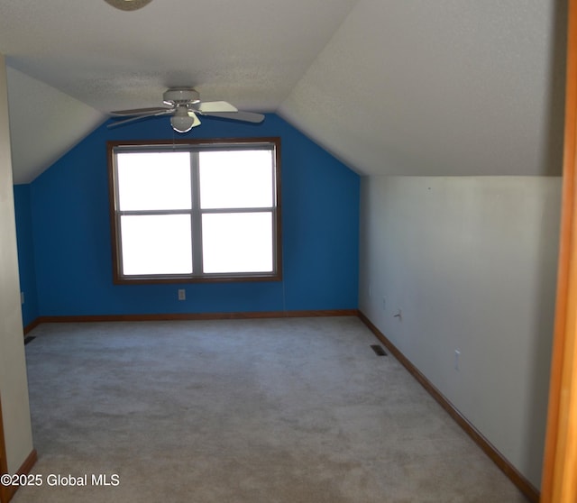 bonus room featuring lofted ceiling, ceiling fan, visible vents, baseboards, and carpet floors