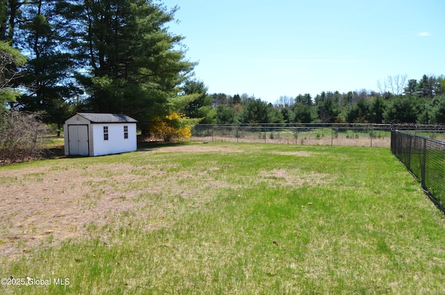 view of yard with an outbuilding, a storage shed, and fence