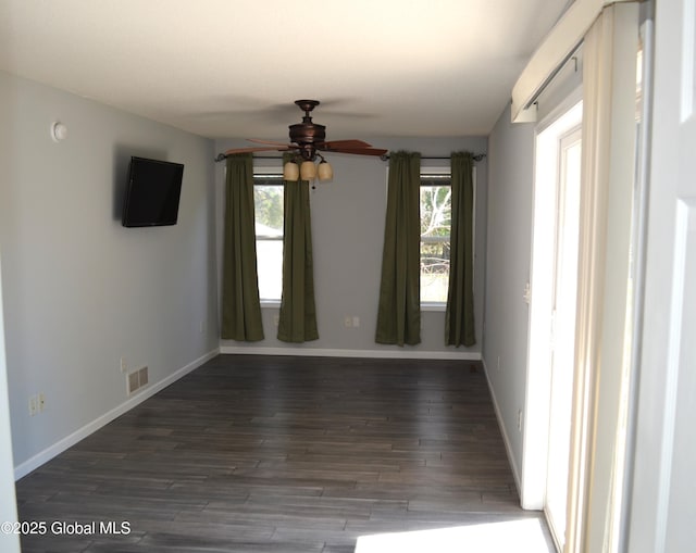 spare room with baseboards, visible vents, wood finished floors, and a ceiling fan