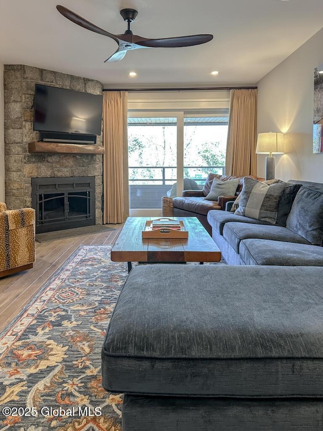 living room featuring recessed lighting, ceiling fan, wood finished floors, and a fireplace