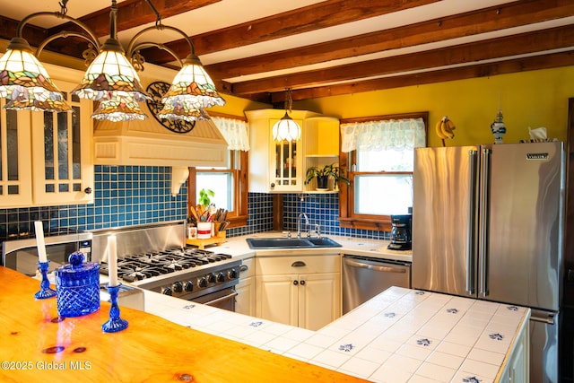 71 S Rd, Hampton, NY 12887 - kitchen featuring a sink, high end appliances, tile countertops, tasteful backsplash, and glass insert cabinets