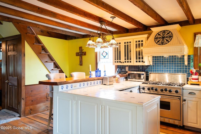 71 S Rd, Hampton, NY 12887 - kitchen featuring stainless steel appliances, premium range hood, a breakfast bar area, dark wood-style floors, and beamed ceiling