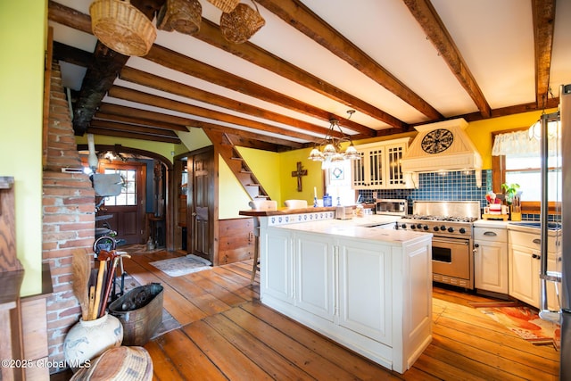 71 S Rd, Hampton, NY 12887 - kitchen with high end stainless steel range oven, premium range hood, healthy amount of natural light, light wood-type flooring, and beamed ceiling