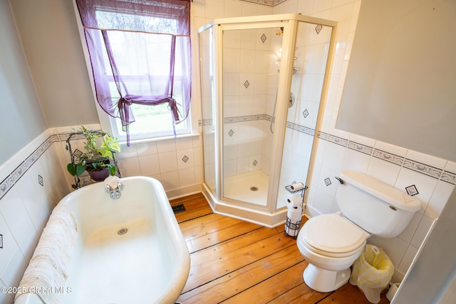 71 S Rd, Hampton, NY 12887 - full bathroom featuring tile walls, a shower stall, hardwood / wood-style flooring, a wainscoted wall, and a tub to relax in